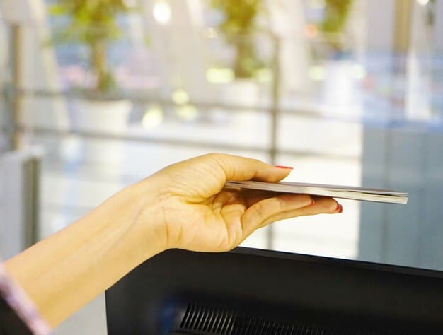 A person's hand holding a smartphone at a self-checkout kiosk, successfully scanning a digital coupon on the screen, emphasizing efficiency.