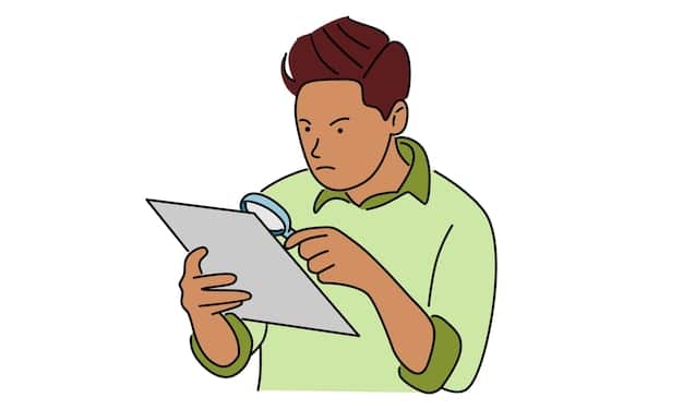 A person holding a magnifying glass over small text on a tablet screen, highlighting 