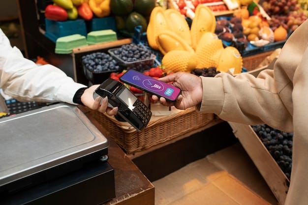 A close-up of a credit card being swiped at a grocery store checkout, with colorful produce blurred in the background. The focus is on the payment transaction.