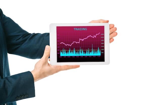A person's hand interacting with a tablet, showing a dynamic chart with fluctuating lines, representing changes in financial programs and the need to monitor them.