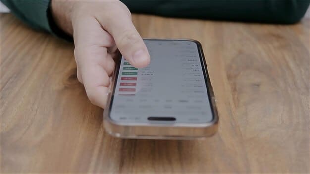 A close-up of a smartphone screen displaying a price history chart, showing price drops over several weeks, with a finger pointing to a recent low.
