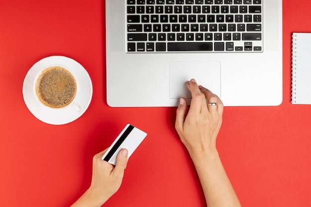 A person's hand holding a credit card, while the other hand types on a laptop keyboard, depicting online shopping and payment.